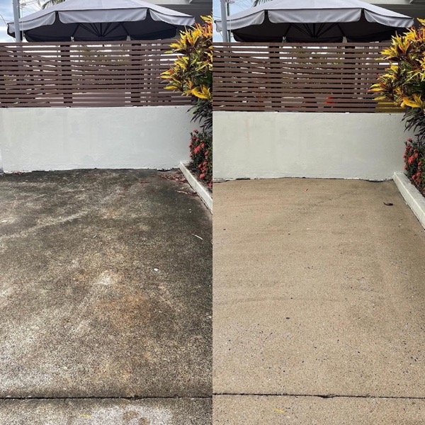 A concrete driveway beside a courtyard with umbrellas, one half dark and the other half pale